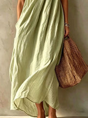 Lower view of a sage one shoulder maxi dress showing the flowing skirt and hem