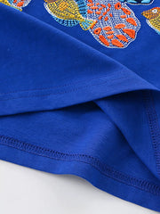 Close-up of royal blue children's t-shirt hem with turtle flipper and fish detail
