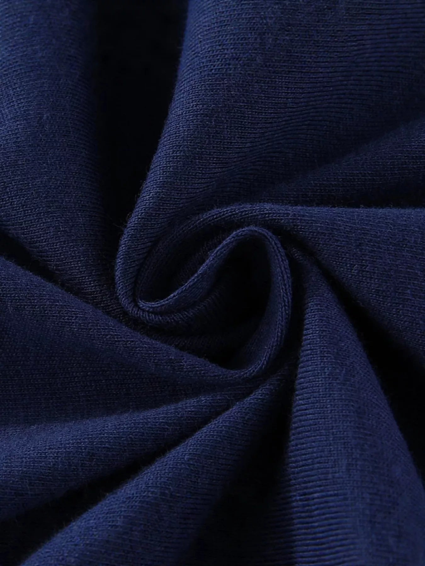 Close-up of the dark navy fabric texture in a soft gathered fold