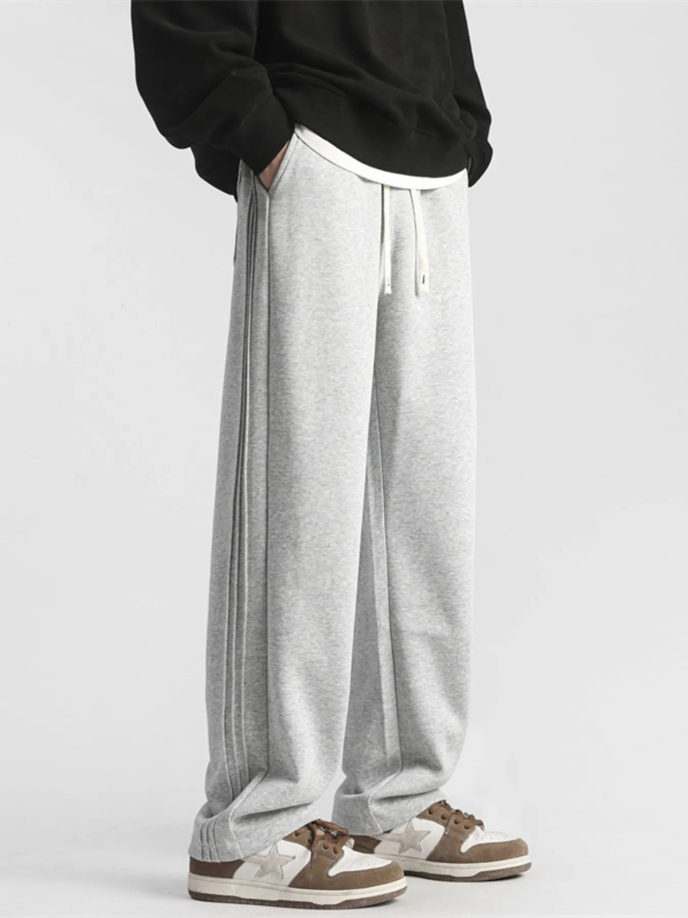 Men's gray loose-fit sweatpants with a drawstring waist and pockets.