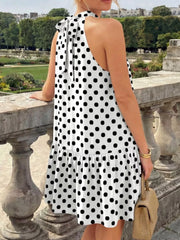 Back view of the white polka dot halter neck mini dress with a neck tie