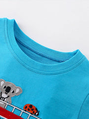 Close-up of ribbed crew neckline and embroidered koala and ladybug on sky blue tee