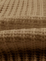 Close view of taupe chunky ribbed knit texture showing thick soft yarn detail.