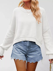Front view of a white crew neck dropped shoulder sweater with ribbed cuffs, arms relaxed at sides.