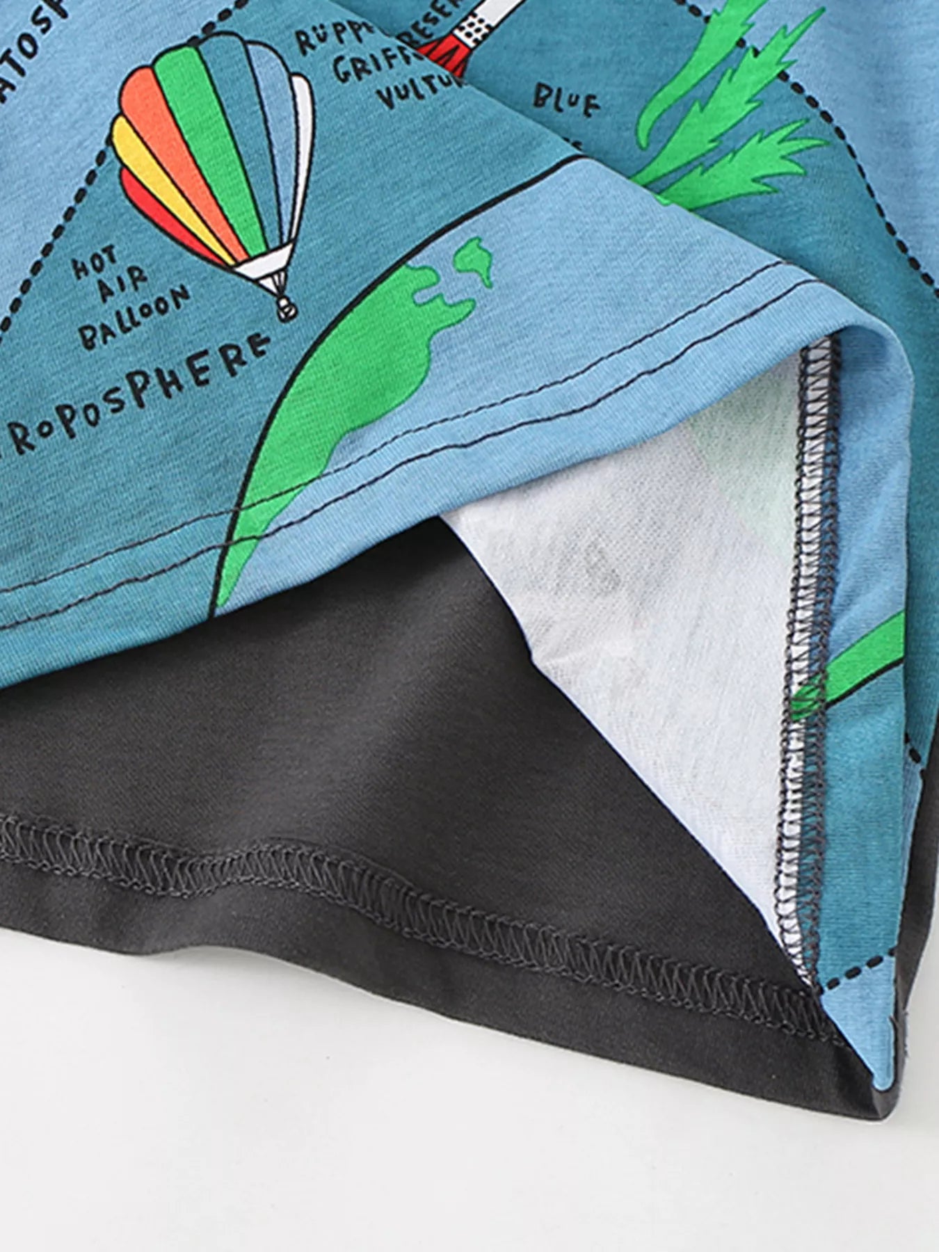 Close-up of the hem stitching and hot air balloon print at the bottom of the gray T-shirt