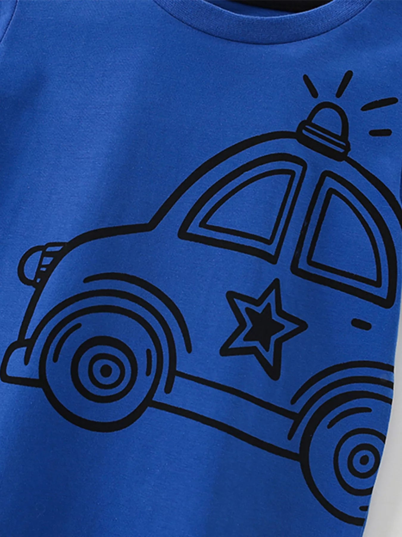 Close view of the black police car graphic with a star on indigo fabric