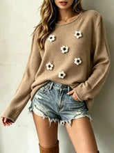 Front view of a khaki textured knit sweater with white floral appliques and long sleeves