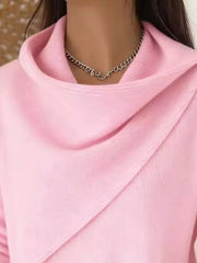 Close-up of the pink cowl neckline showing the draped asymmetric collar and fine knit texture