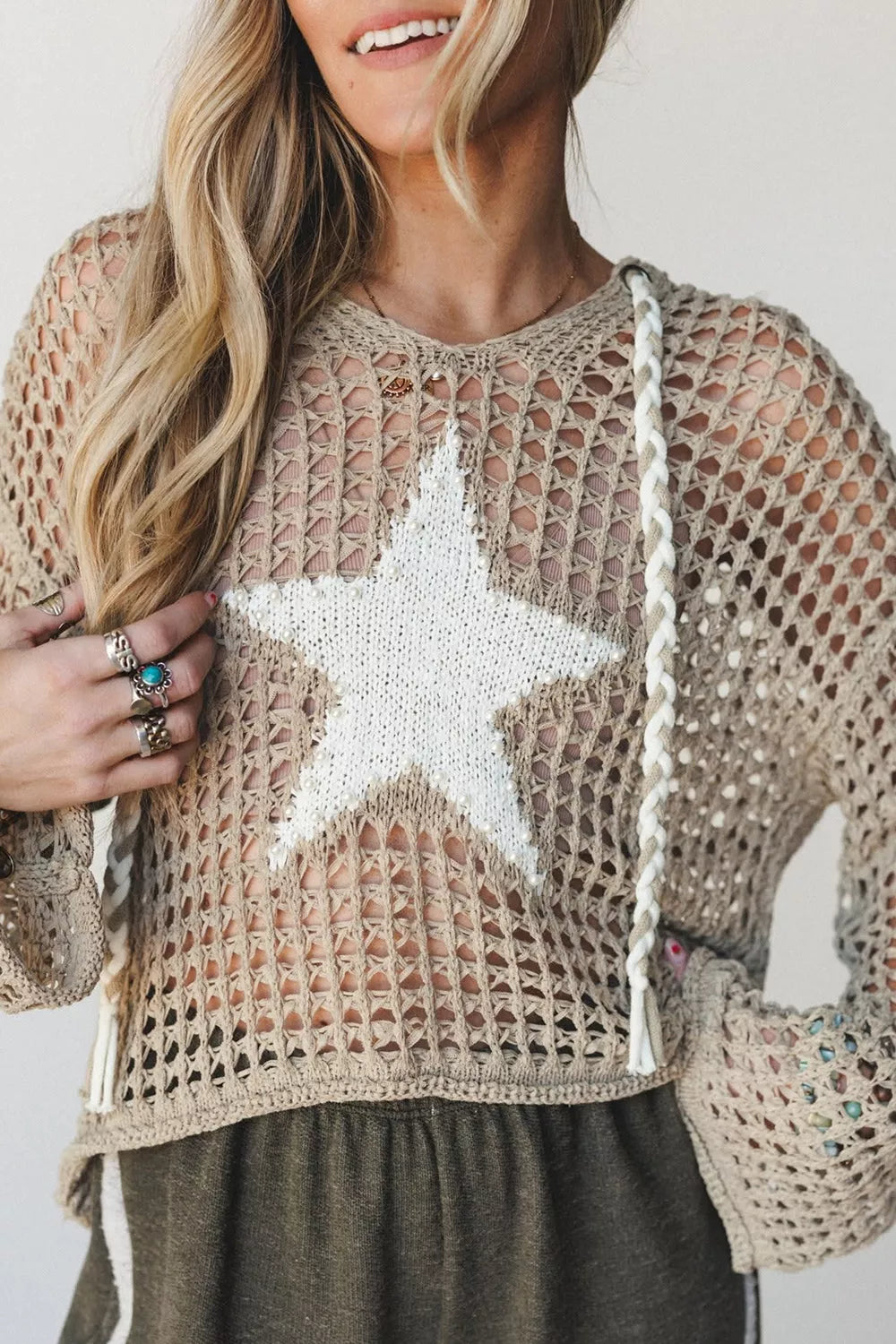Close front view of mocha openwork crochet hooded cover up with large white star.