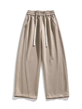 Men's khaki loose-fit wide-leg pants with a drawstring waist and pockets.