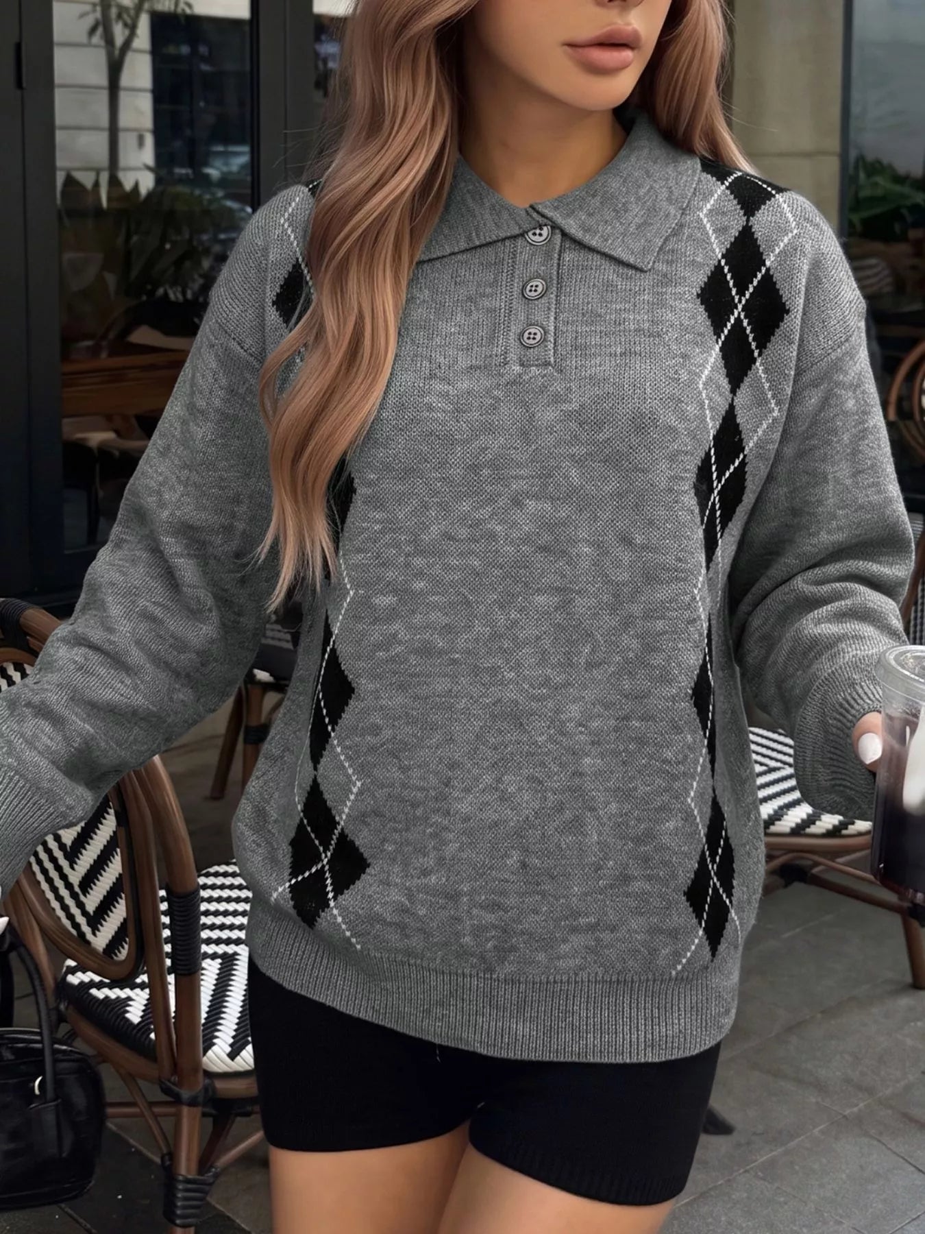 Front view of a gray argyle polo collar sweater with long sleeves and ribbed cuffs