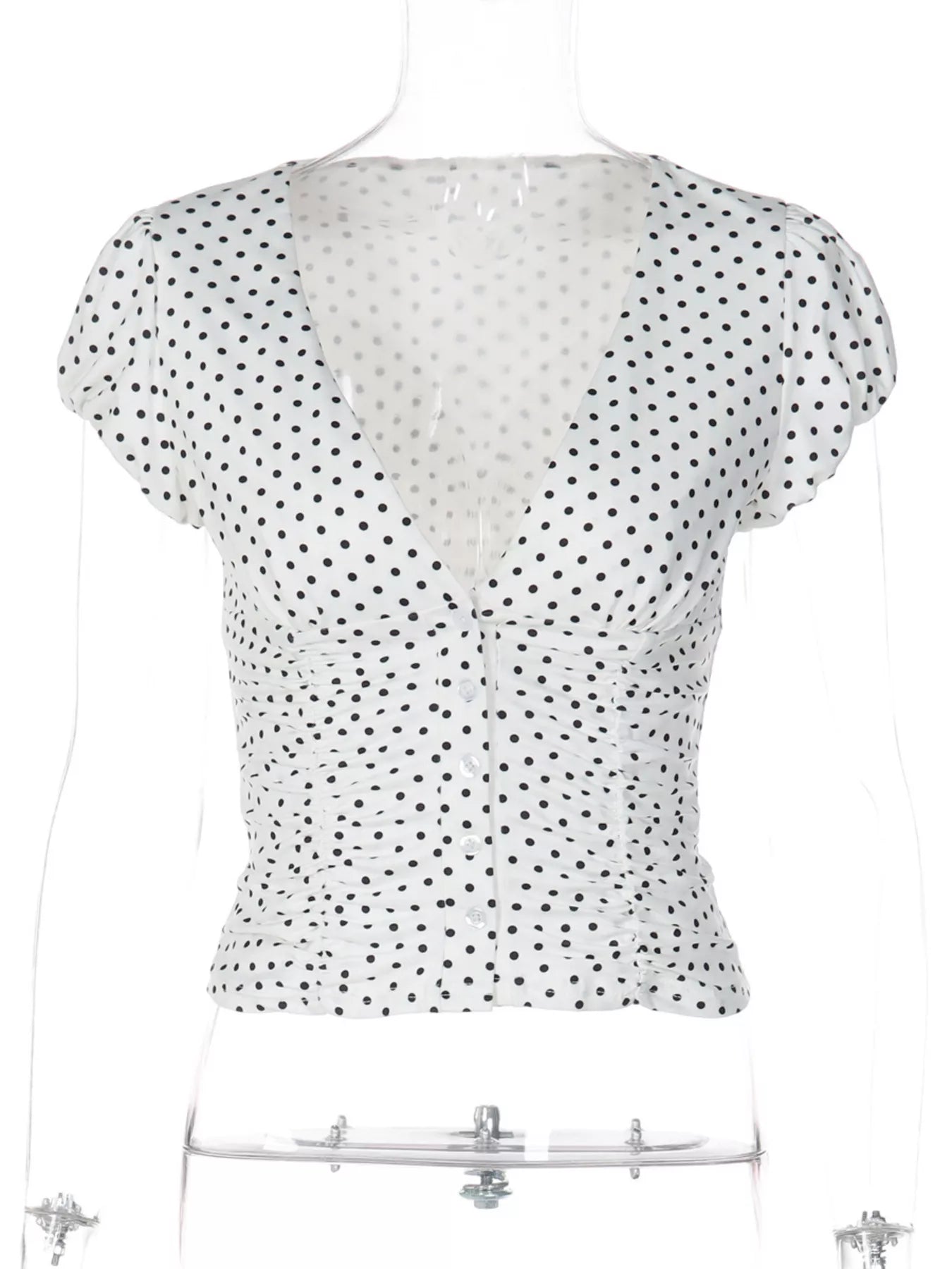 White polka dot ruched top with short sleeves, V-neckline, and button-front closure on a mannequin