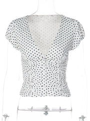 White polka dot ruched top with short sleeves, V-neckline, and button-front closure on a mannequin