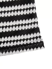 Close up flat detail of a black and white striped knit dress hem