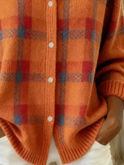 Close-up of the lower front and ribbed hem of an orange and red plaid knit cardigan