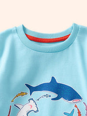 Detail view of the crew neckline with red inner trim on a children's pastel blue shark print t-shirt