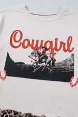 Close-up of white T-shirt featuring red “Cowgirl” lettering, a horseback rider graphic, stars, and horseshoe accents.