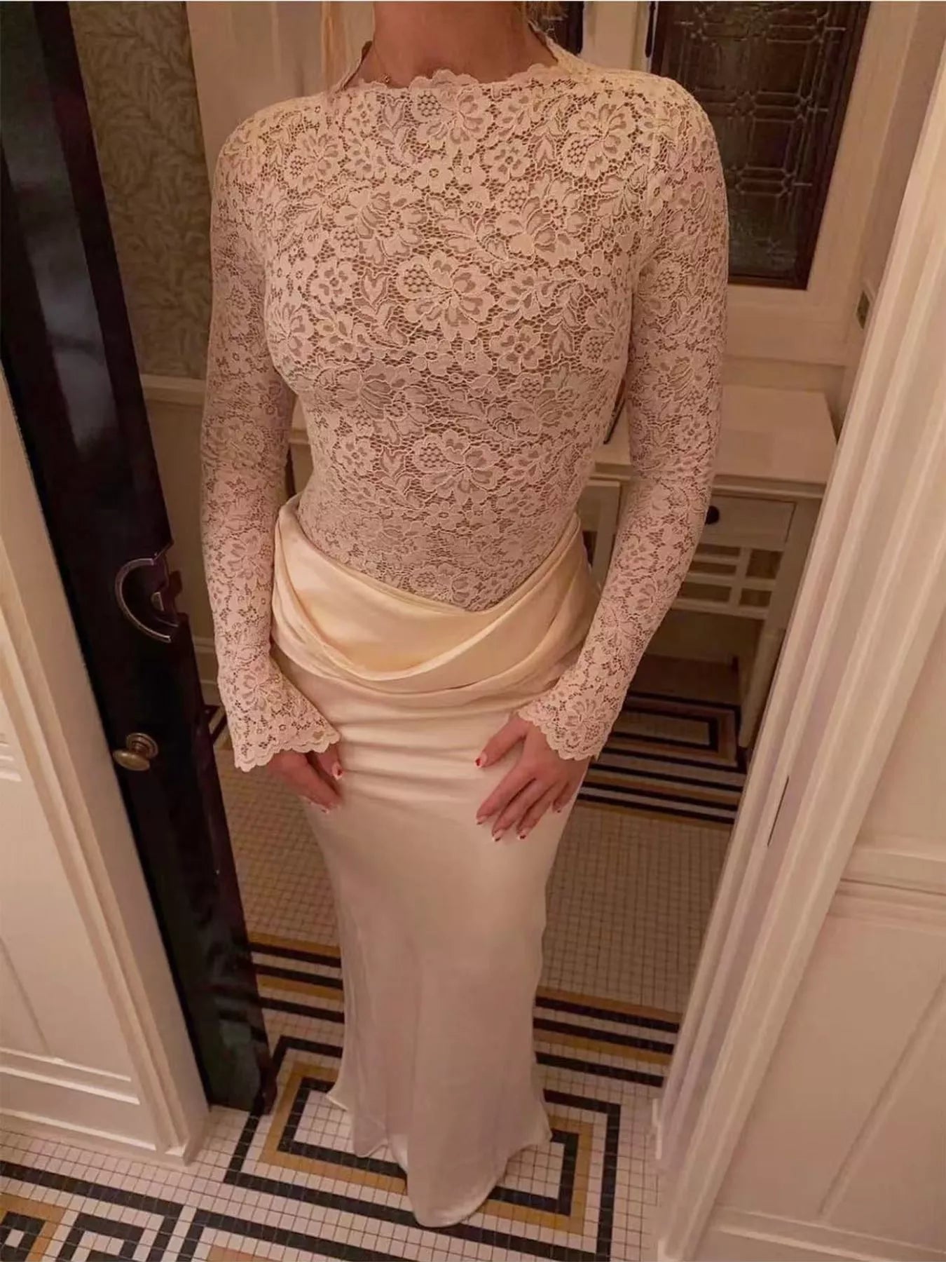 Full length ivory lace and satin maxi dress worn indoors in a doorway