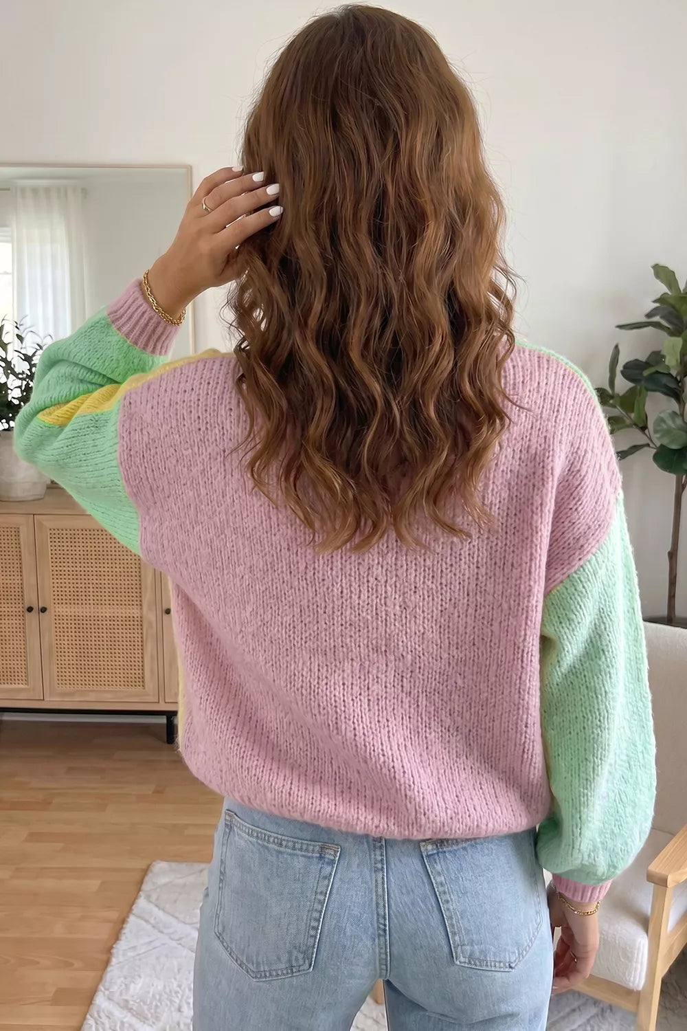 Back view of the pink knit cardigan with mint green patchwork sleeves