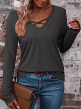 Dark gray long-sleeve T-shirt with crisscross V-neck detail, shown styled with jeans.