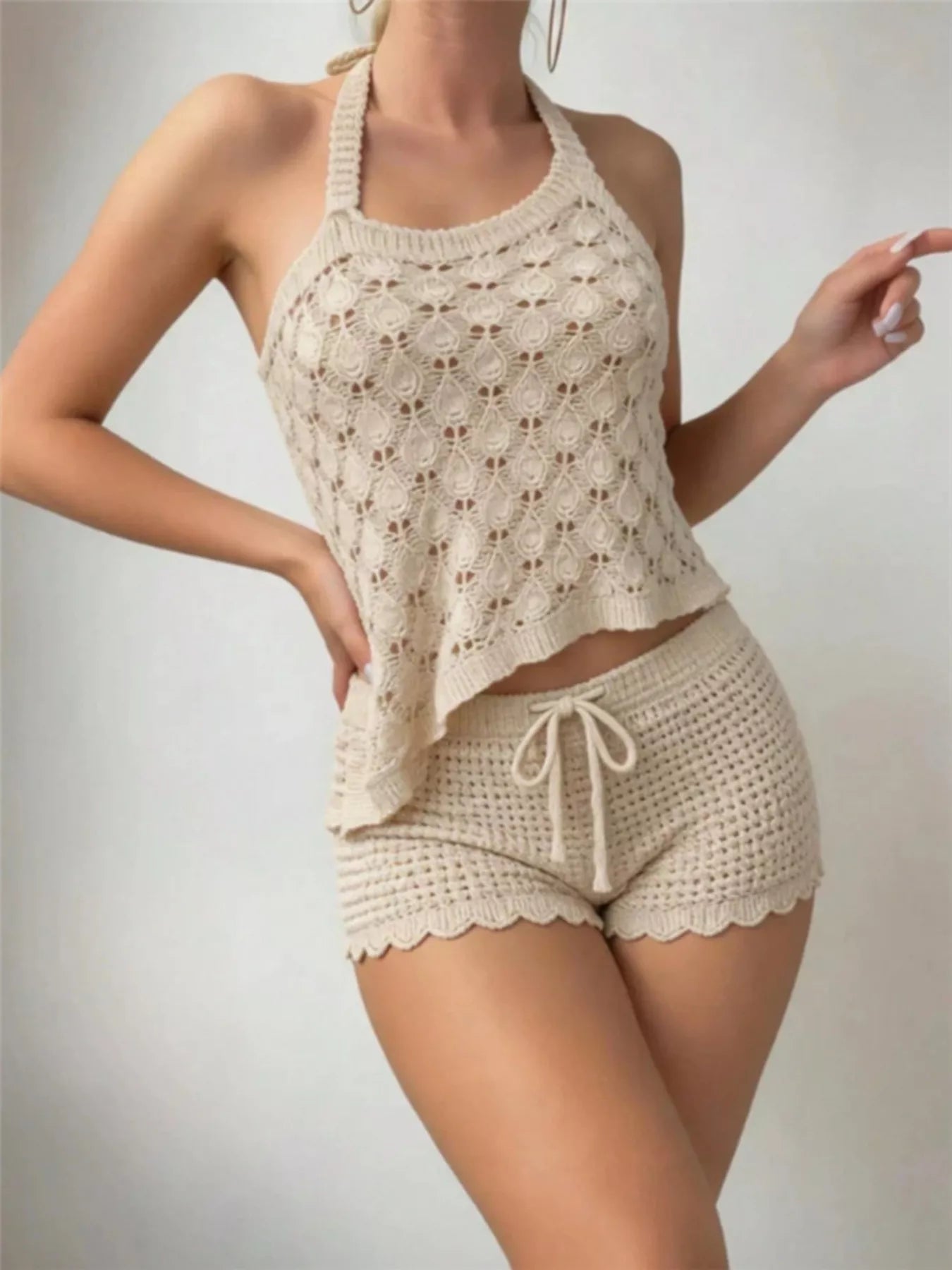 Studio front view of a cream crochet halter top and scalloped shorts set.