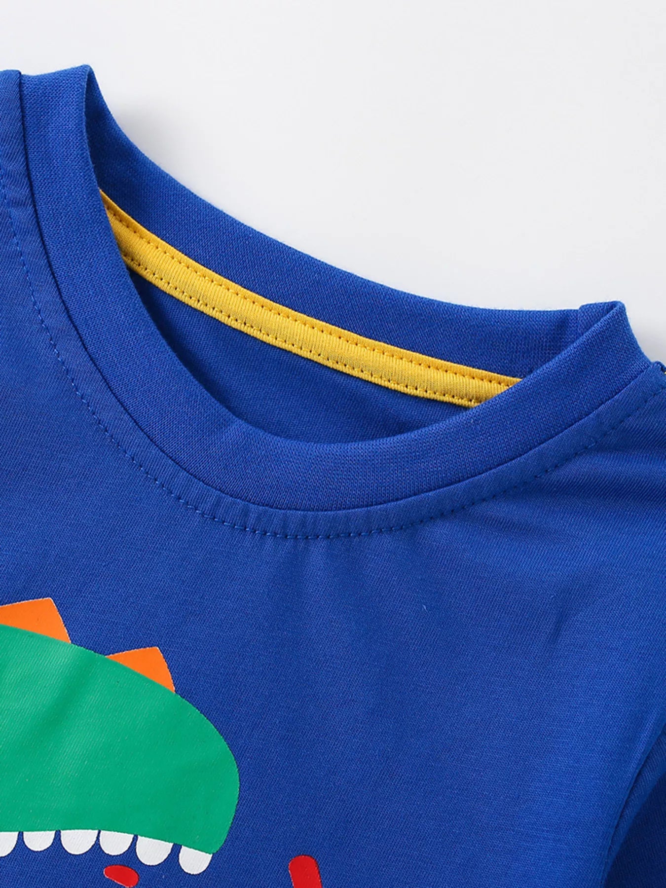Close-up of royal blue children's t-shirt collar with yellow inner neck trim