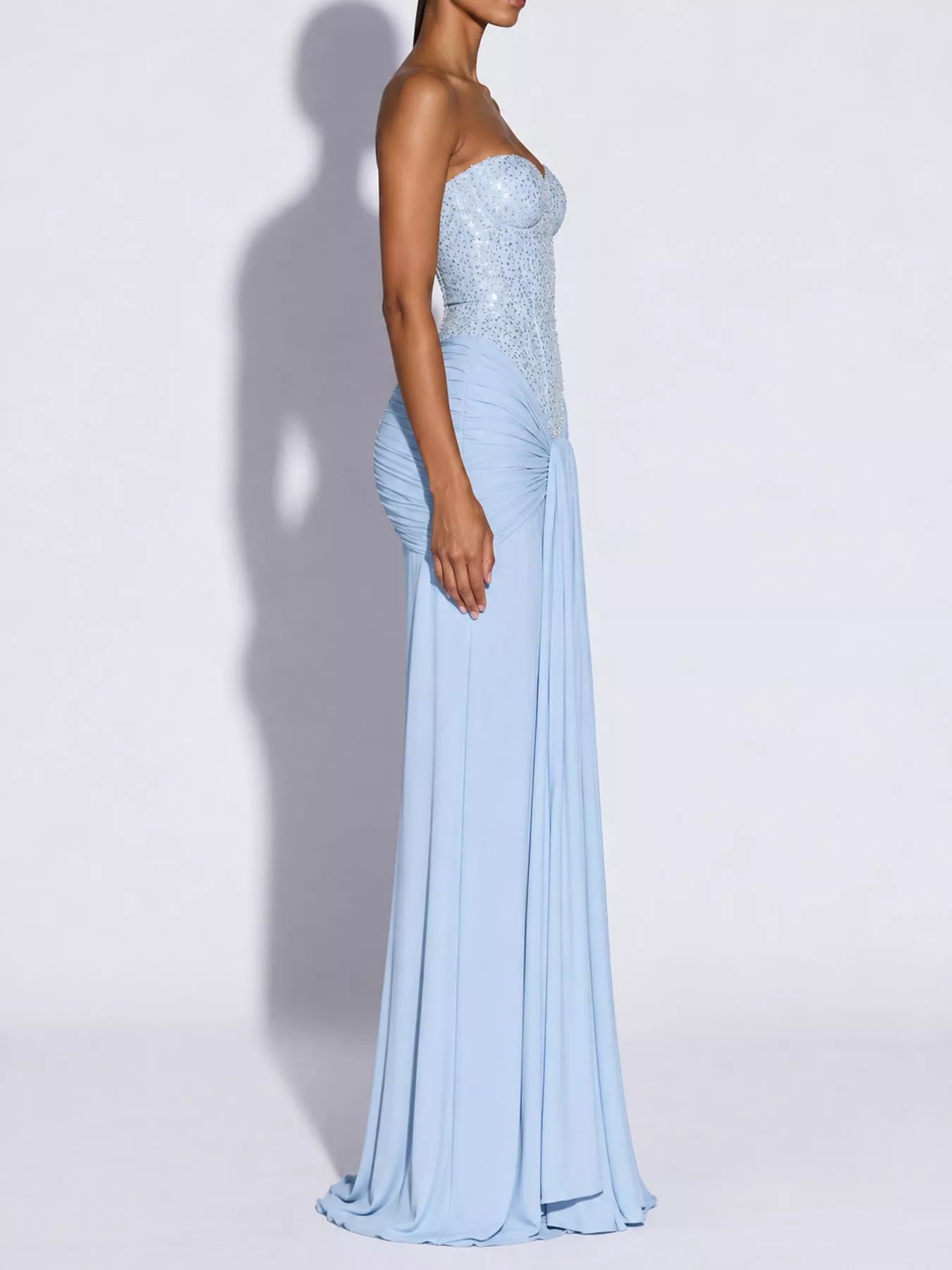 Blue strapless sequin corset maxi dress on model, full length side profile in studio