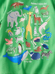 Detail view of the lower animal alphabet print with whale yak and zebra on a children's green t-shirt
