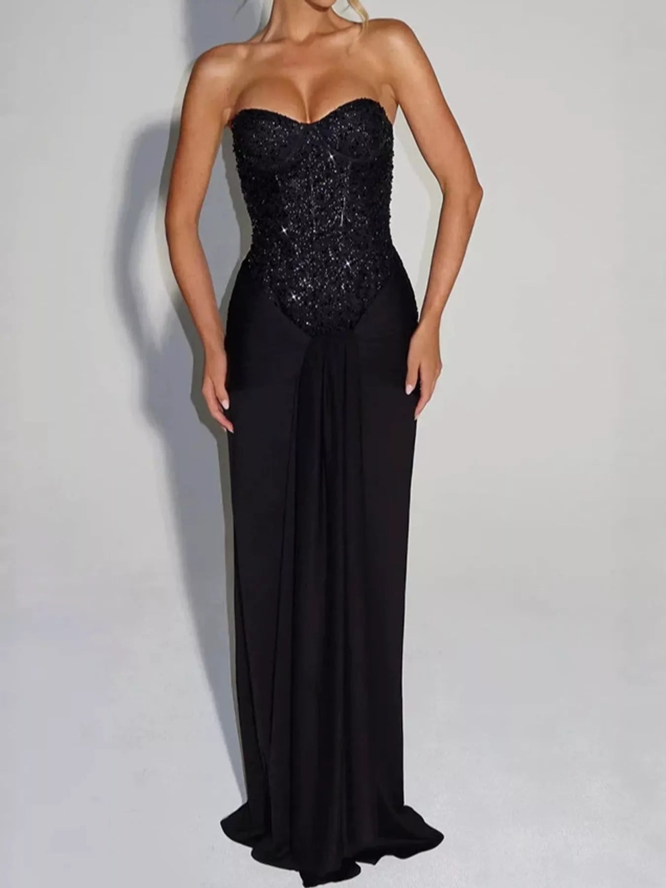Black strapless sequin corset maxi dress with draped waist on model, studio front view