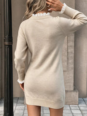 Back view on model of beige cable knit sweater dress with white lace collar and cuffs