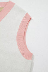 Close-up of the pink ribbed armhole trim on the cream sweater vest