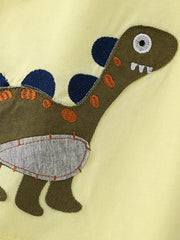 Close-up detail of the green dinosaur applique with blue spikes and orange stitching