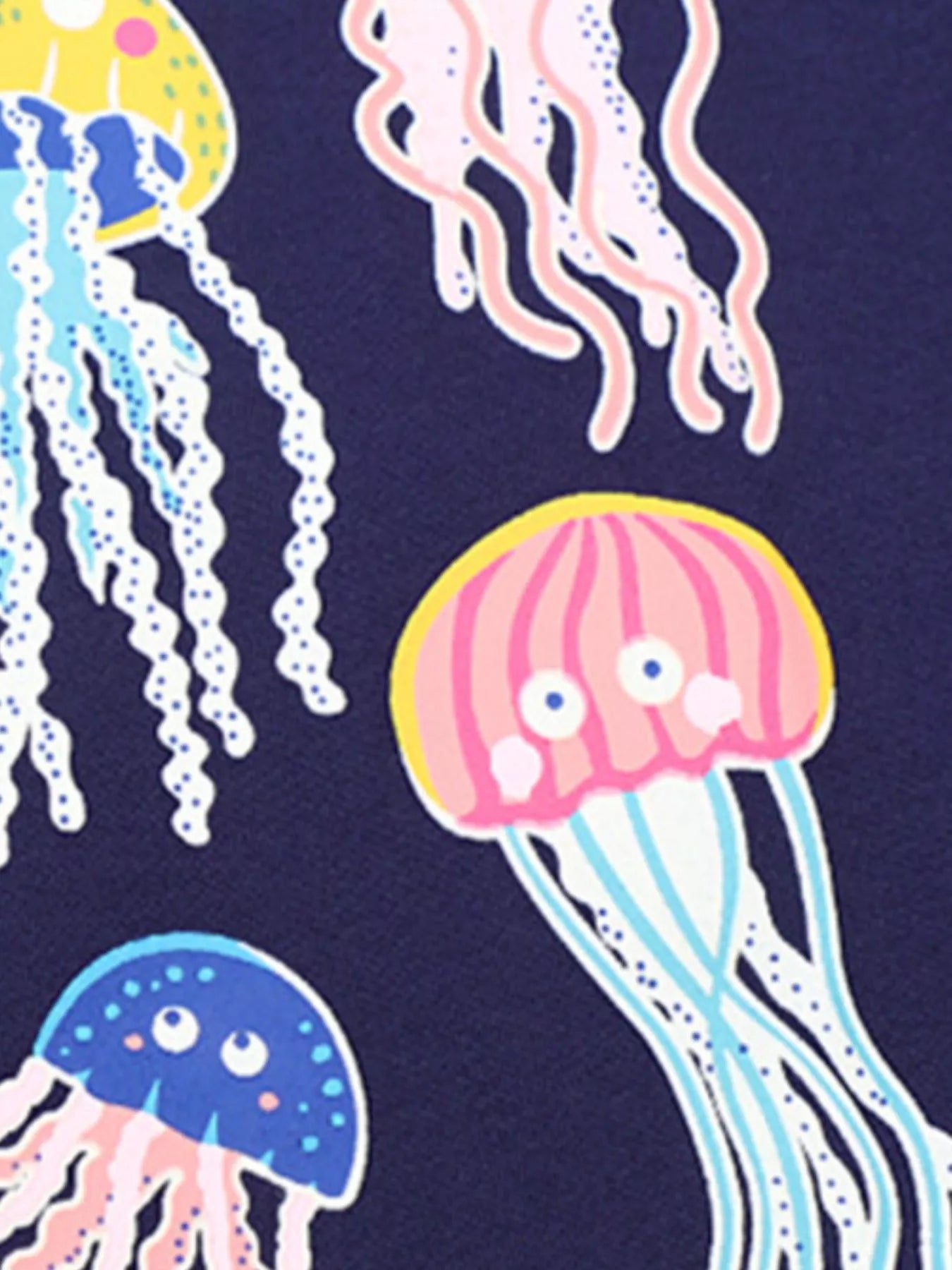 Close-up of pink and blue cartoon jellyfish print on black children's tee