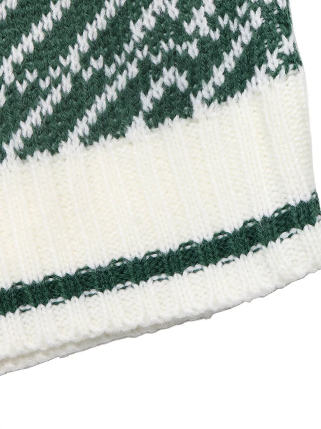 Close-up of the white ribbed hem with a green stripe on the geometric sweater