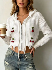 White knit zip up hooded sweater with red cherry appliques worn on model holding coffee