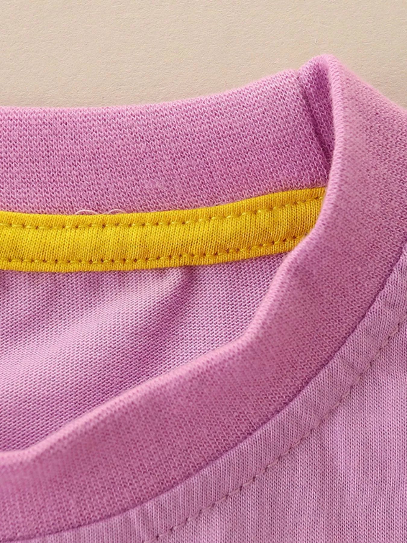 Close-up of the dusty pink neckline with a yellow inner trim and fine stitching