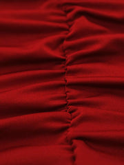 Close detail of burgundy ruched fabric and side seam of bodycon mini dress