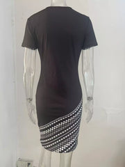 Black round neck bodycon mini dress with white geometric diagonal skirt panel, back view on mannequin