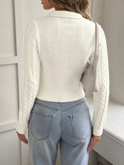 Back view of white cable knit long sleeve sweater with ribbed hem, model carrying bag