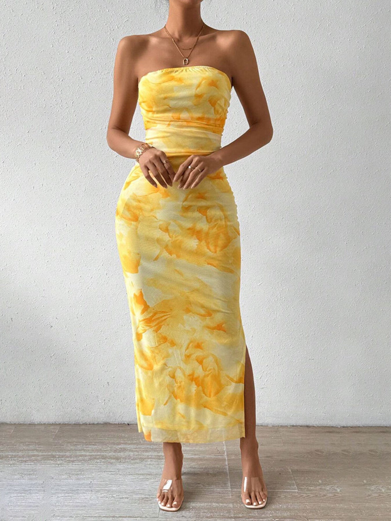 Front view of yellow ruched strapless bodycon midi dress with abstract print