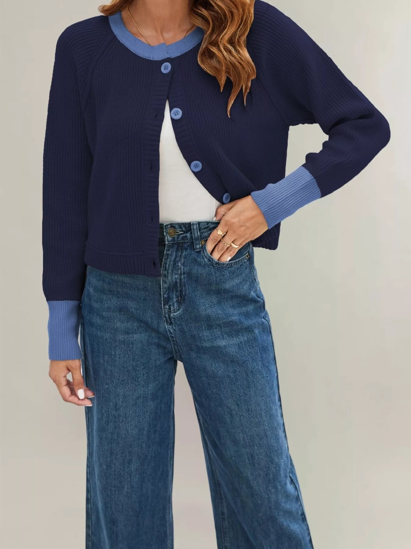On-model front view of a navy ribbed cardigan with light blue trim and blue buttons