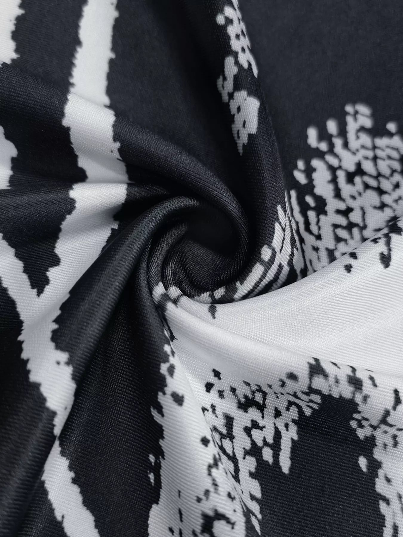Close view of black and white abstract print fabric on a sleeveless bodycon maxi dress