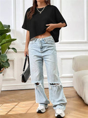 Black waffle-knit cropped short-sleeve top shown on a model in a lifestyle outfit