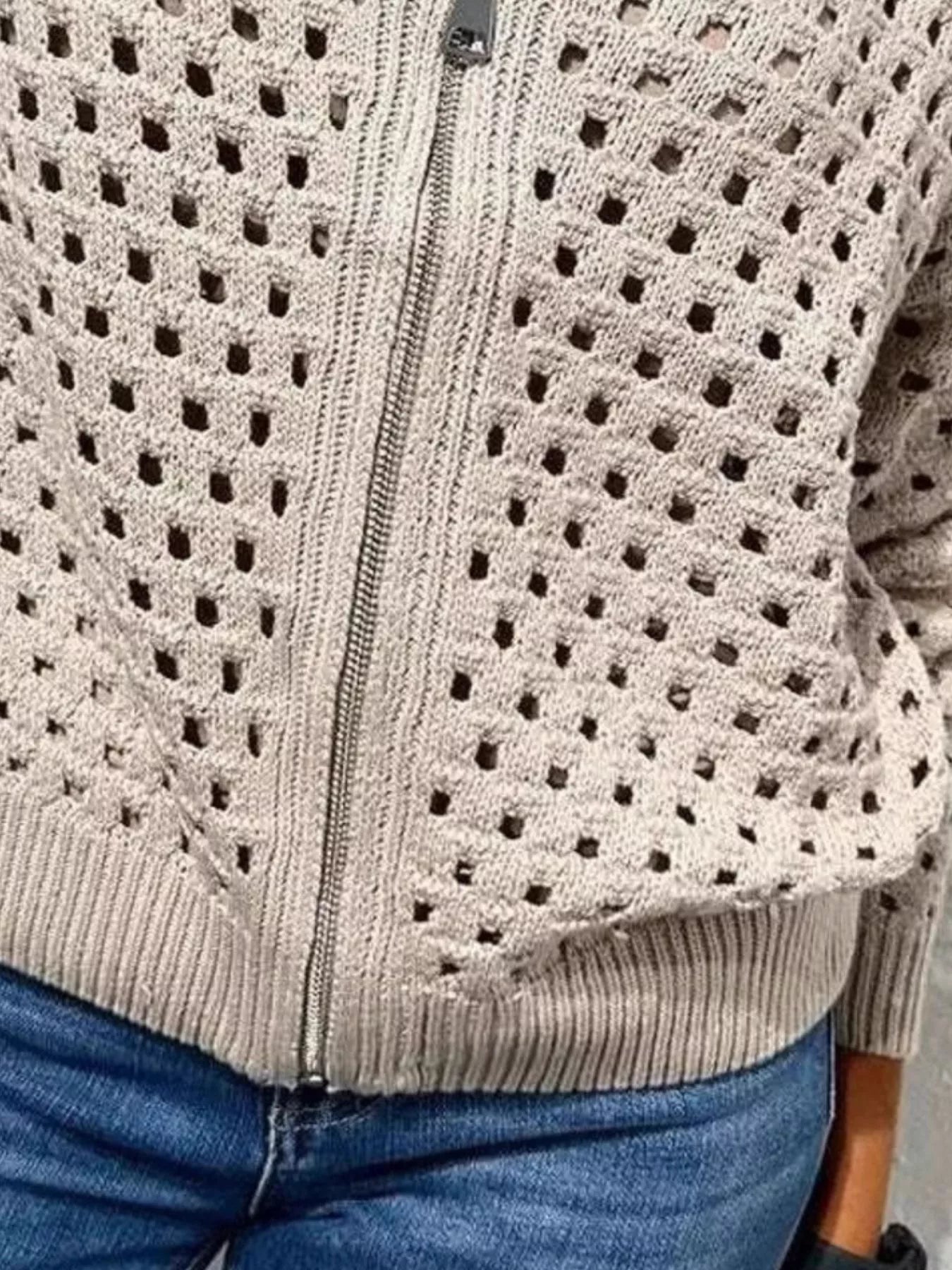 Close up of the pale beige crochet cardigan lower zip and ribbed hem