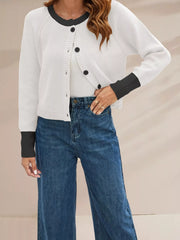 On-model front view of a white ribbed cardigan with black trim and black buttons