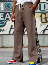 Men's dark brown wide-leg pants with side snaps and a drawstring waist.
