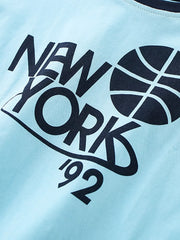 Close-up detail of the dark navy NEW YORK basketball graphic on pastel blue fabric