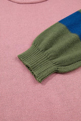 Close up of the green ribbed sleeve cuff against the pink sweater body