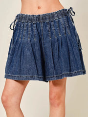Women's pleated denim shorts with an elastic waistband, ruched detailing, and ties.