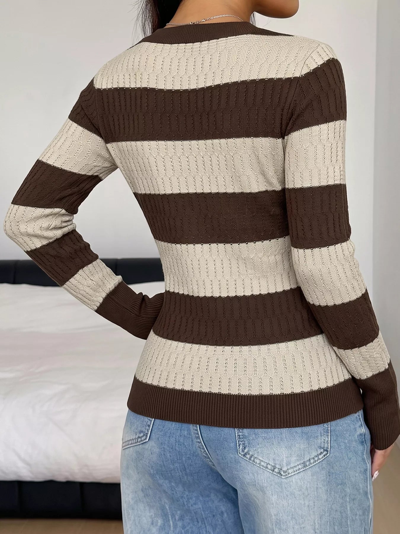Back view of the brown and cream striped long sleeve knit top with jeans